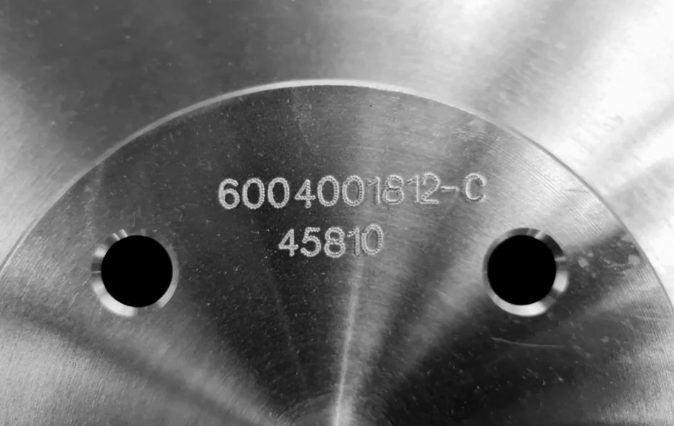 Dot peen marking on a machined metal component for durable part identification and traceability.
